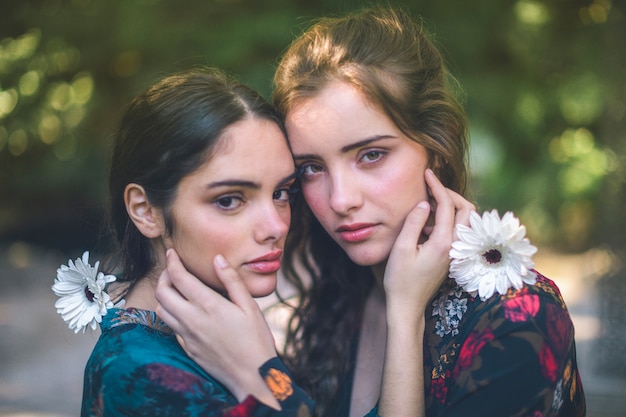 Hermosas mujeres sosteniendo flores y abrazos