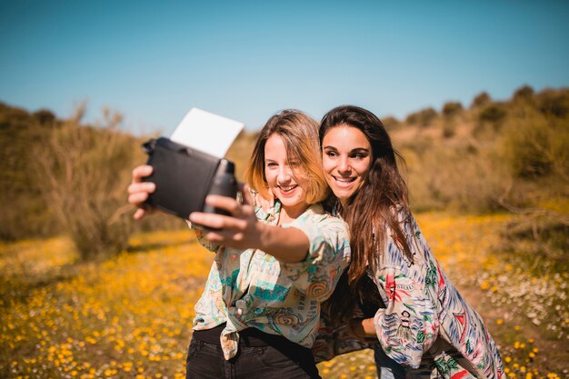 Hermosas mujeres tomando selfie en el campo