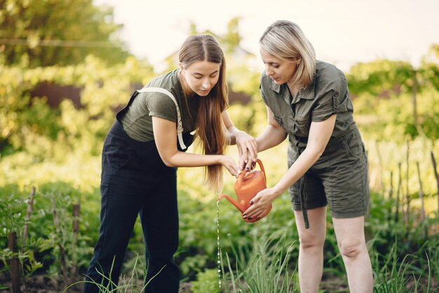 Hermosas mujeres trabajan en un jardín cerca de la casa.