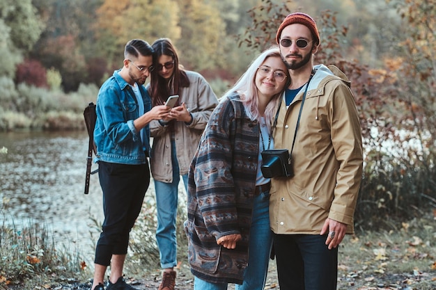 Hermosas parejas románticas de jóvenes disfrutan de su paseo por el parque de otoño.