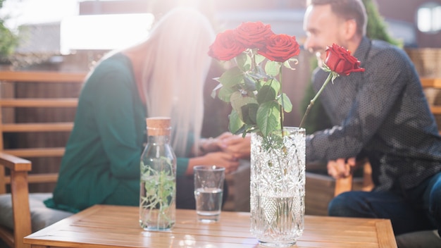 Hermosas rosas en frente de pareja que datan juntos