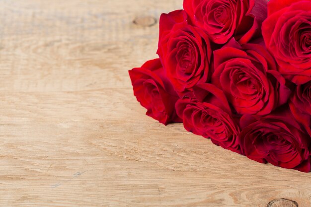 Hermosas rosas en mesa de madera