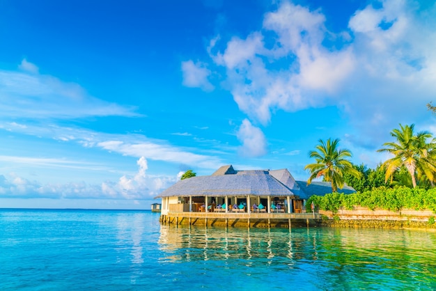 Hermosas villas de agua en la isla tropical de Maldivas en el momento de la salida del sol