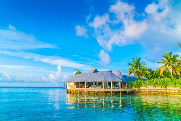 Hermosas villas de agua en la isla tropical de Maldivas en el momento de la salida del sol