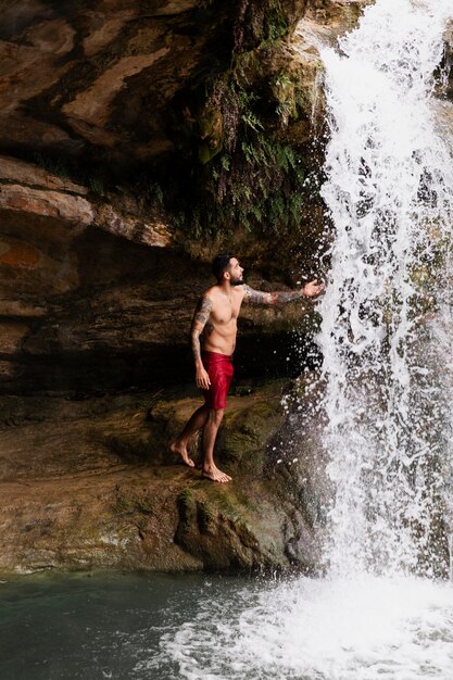 Hermoso, adulto joven, por, la, cascada