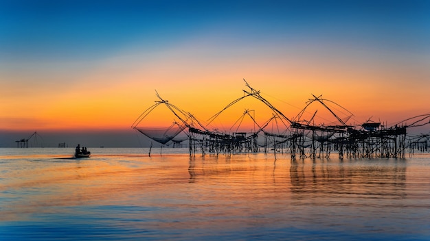 Hermoso amanecer y redes de inmersión de pesca en Pakpra en Phatthalung, Tailandia.