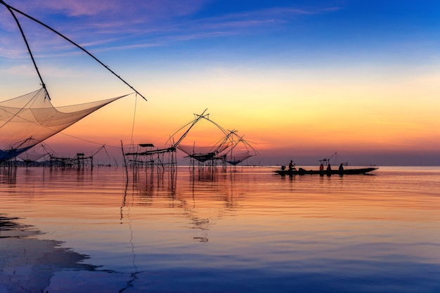 Hermoso amanecer y redes de inmersión de pesca en Pakpra en Phatthalung, Tailandia.