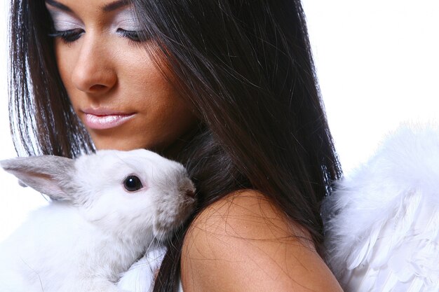 Hermoso ángel con conejito blanco