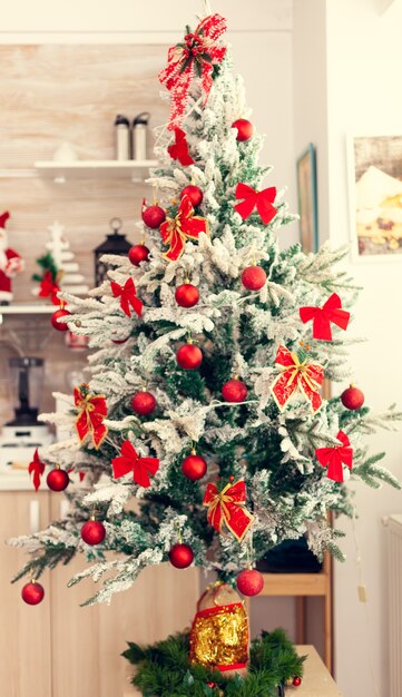 Hermoso árbol de Navidad decorado en la cocina vacía