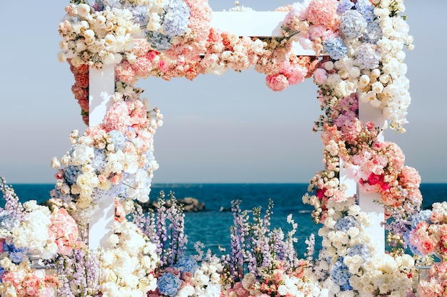 Foto gratuita hermoso arco de boda decorado cerca del mar