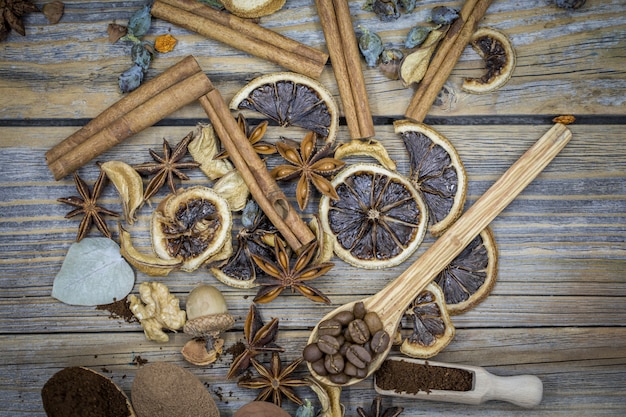 Un hermoso arreglo de limones secos, canela, café en cucharas de madera sobre madera.