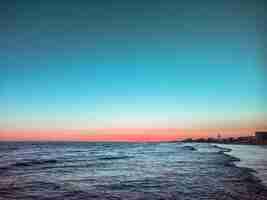 Foto gratuita hermoso atardecer en el mar y olas pequeñas.