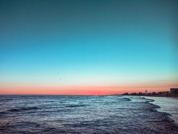 Hermoso atardecer en el mar y olas pequeñas.