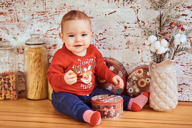 Hermoso bebé se sienta en la mesa sosteniendo una nuez