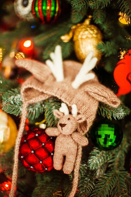 Hermoso bebé sombrero y juguetes en el árbol de Año Nuevo