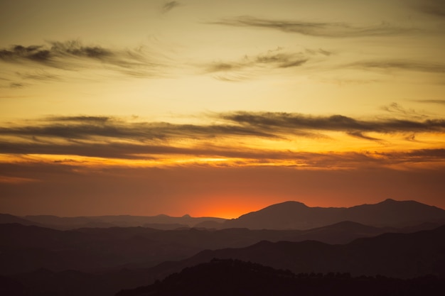 Hermoso cielo en tonos amarillos con montañas