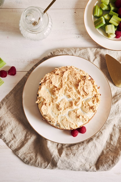 Foto gratuita hermoso y delicioso pastel de frambuesa y ruibarbo con ingredientes sobre una mesa