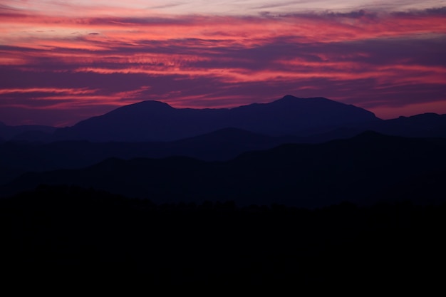 Hermoso diseño de cielo violeta y rojo con montañas