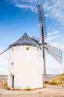 Foto gratuita hermoso disparo vertical de un molino de piedra blanca sobre un cielo azul en consuegra, españa