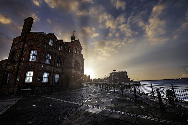 Hermoso edificio cerca del mar en Liverpool durante la puesta de sol