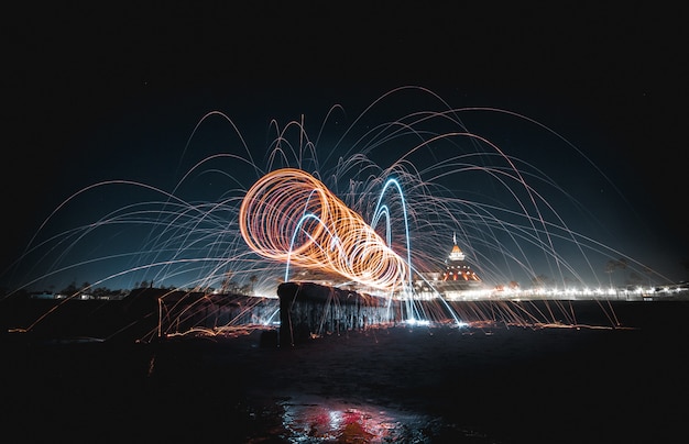 Hermoso espectáculo de luz giratoria impresionante y hermoso por la noche sobre un lago