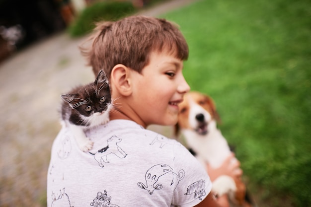 Hermoso gatito se sienta en el hombro del niño