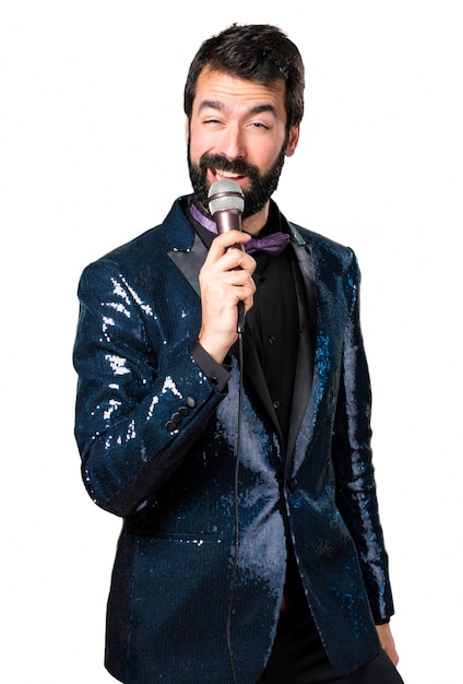 Hermoso hombre con chaqueta de lentejuelas cantando con micrófono