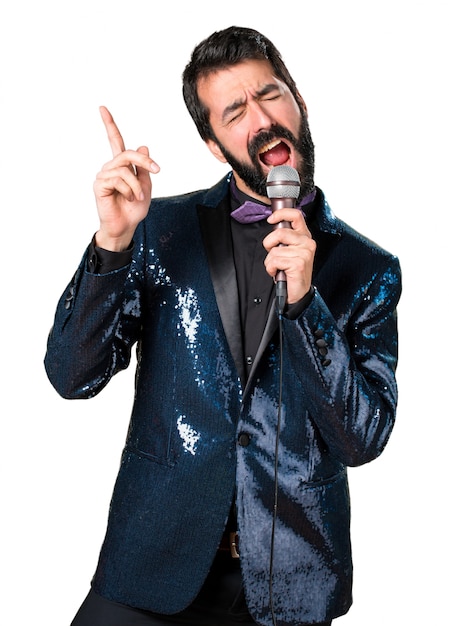 Hermoso hombre con chaqueta de lentejuelas cantando con micrófono