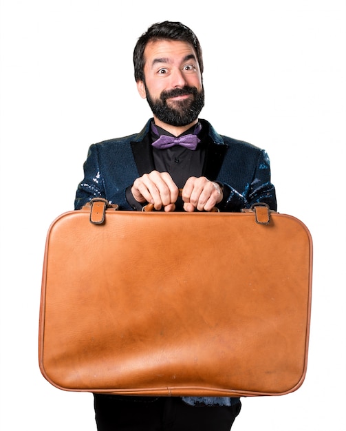 Foto gratuita hermoso hombre con chaqueta de lentejuelas sosteniendo un maletín vintage