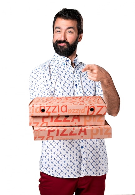 Hermoso hombre morena con barba sosteniendo una pizza