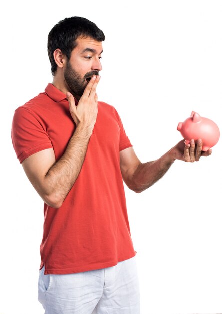 Hermoso hombre con un piggybank