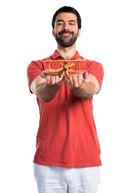 Hermoso hombre sosteniendo un avión de juguete de madera