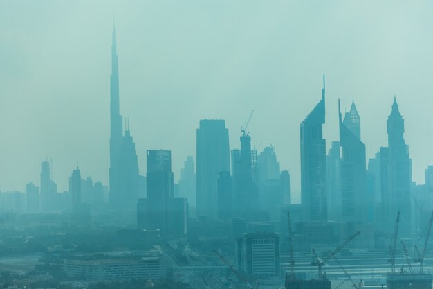 Hermoso horizonte de Dubai rodeado de polvo de arena a la luz del día