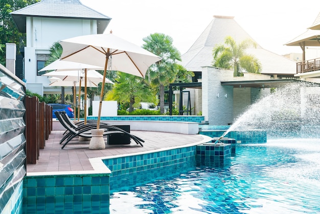 Hermoso hotel de lujo piscina piscina con sombrilla y silla