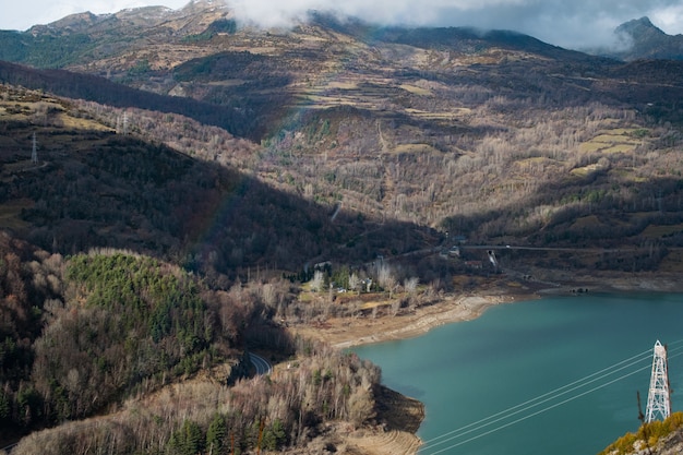 Hermoso lago rodeado de altas montañas rocosas bajo un cielo nublado