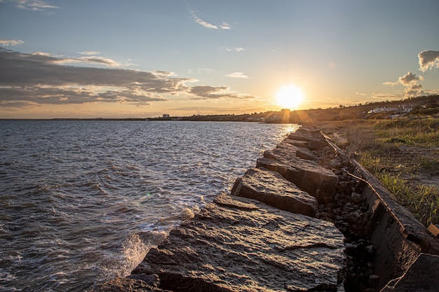 Hermoso mar al atardecer cerca de la costa rocosa. Composición de la naturaleza