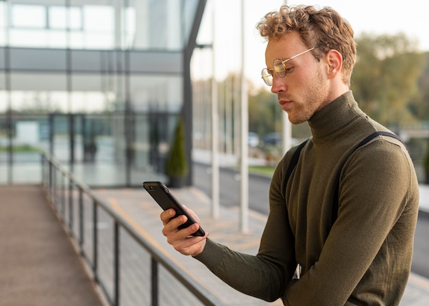 Hermoso modelo masculino navegando a través de su teléfono