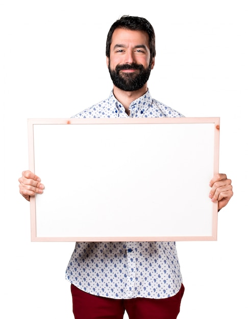 Hermoso morena hombre con barba sosteniendo un cartel vacío