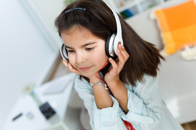 Hermoso niño escuchando música y baile en casa.