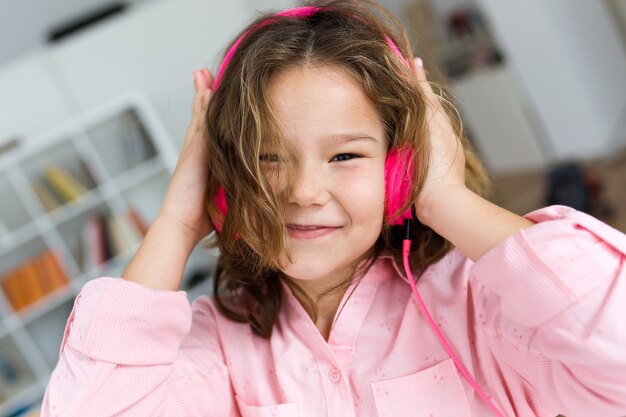 Hermoso niño escuchando música y baile en casa.