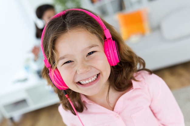 Hermoso niño escuchando música y baile en casa.