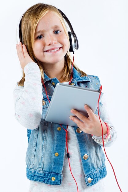 Hermoso niño escuchando música con tableta digital.