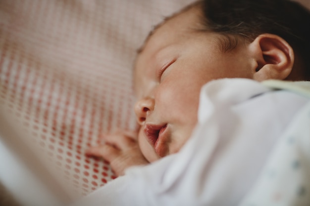 Hermoso niño recién nacido se acuesta en una cama y duerme