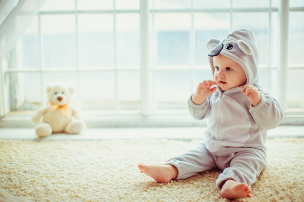 hermoso niño sentado en la ventana