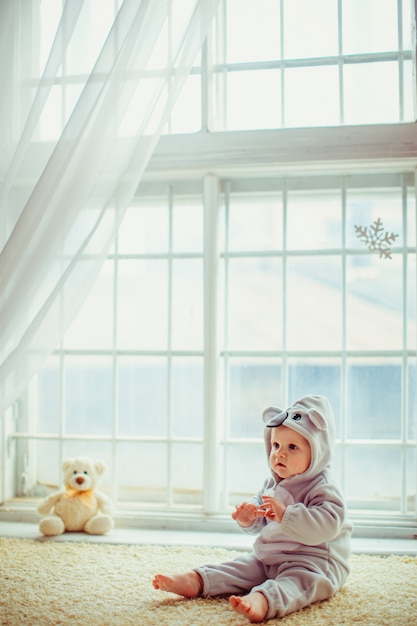 hermoso niño sentado en la ventana