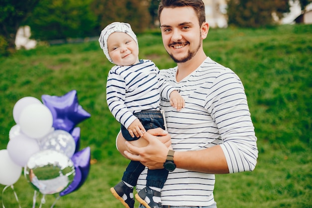 hermoso padre alto y elegante en un suéter y jeans está golpeando con su pequeño hijo dulce