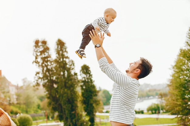 hermoso padre alto y elegante en un suéter y jeans está golpeando con su pequeño hijo dulce