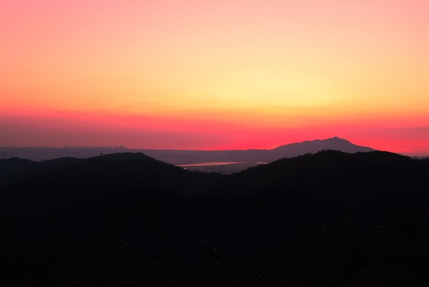 Hermoso paisaje de altas colinas cubiertas de hierba bajo el impresionante cielo del atardecer