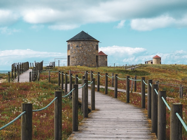 Foto gratuita hermoso paisaje de un antiguo molino de viento tradicional en sandhills de apulia en portugal