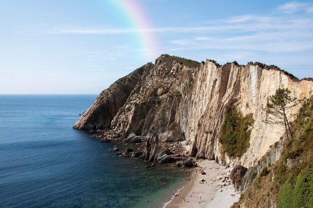 Hermoso paisaje con arco iris y mar.